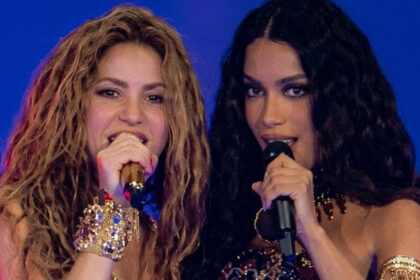 Shakira e Anitta cantando juntas ao microfone em um palco